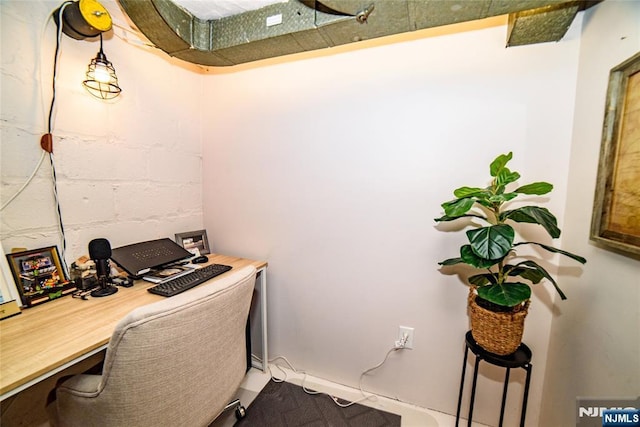 office space with concrete block wall