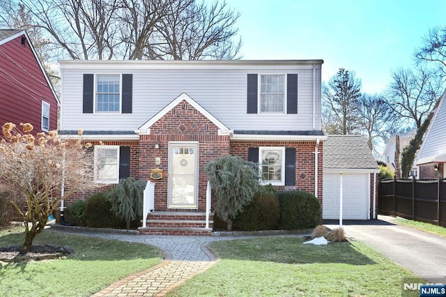 view of front of house featuring driveway, an attached garage, a front lawn, and brick siding