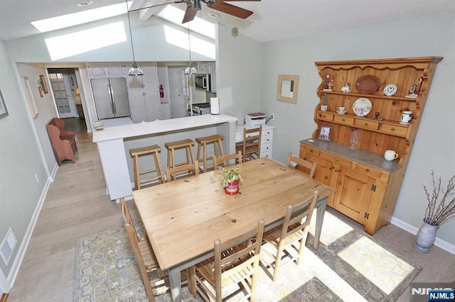 dining space featuring a ceiling fan, light wood-type flooring, lofted ceiling, and baseboards