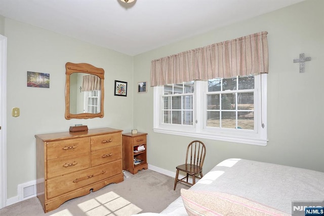 bedroom featuring visible vents, light carpet, and baseboards