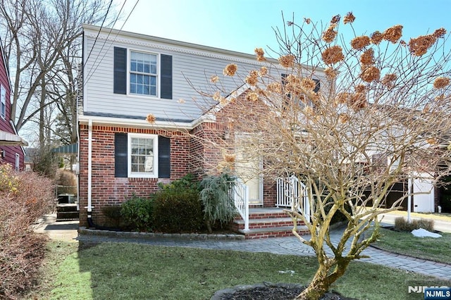 view of front of home with brick siding and a front lawn