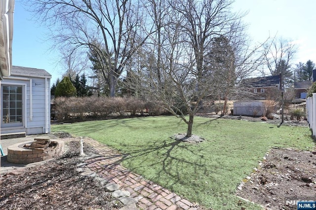 view of yard with an outdoor fire pit and fence