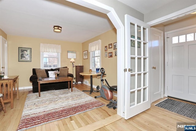 foyer entrance featuring arched walkways, hardwood / wood-style floors, and baseboards