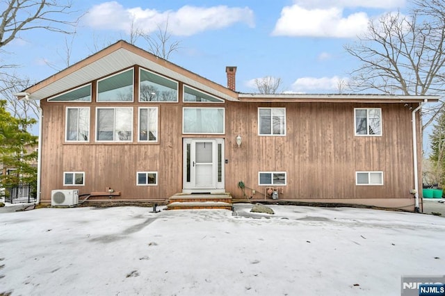 view of front of home featuring ac unit and a chimney