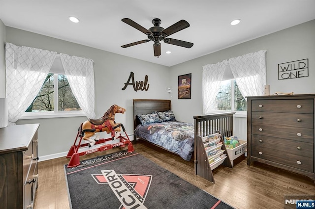 bedroom with multiple windows, baseboards, wood finished floors, and recessed lighting