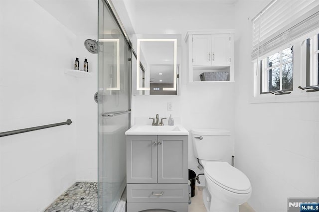 full bathroom with a stall shower, vanity, and toilet