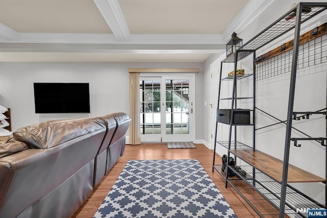 living room featuring ornamental molding, french doors, beamed ceiling, and light wood-style flooring