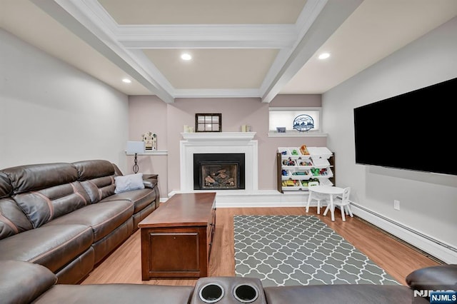 living room with a baseboard heating unit, beamed ceiling, a fireplace, and light wood-style floors