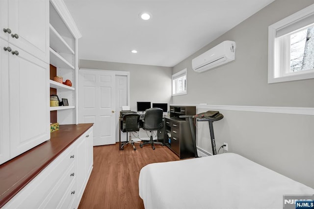 bedroom featuring a wall mounted AC, wood finished floors, and recessed lighting