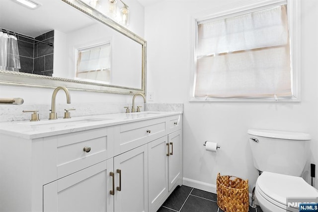 full bath with double vanity, a sink, toilet, and tile patterned floors