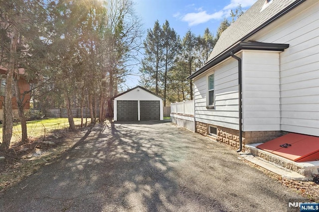 view of yard featuring an outbuilding, a detached garage, and fence