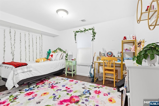 bedroom with wood finished floors and visible vents