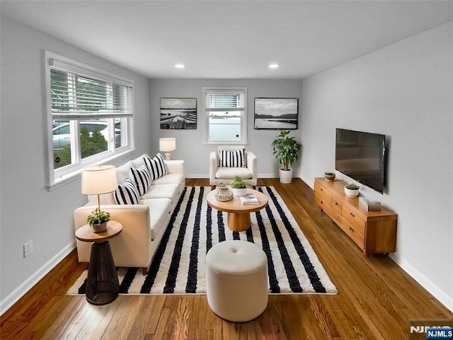 living room featuring recessed lighting, baseboards, and wood finished floors