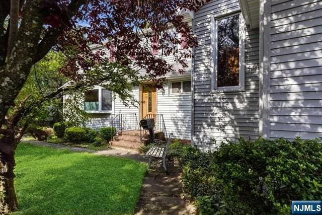 doorway to property with a lawn