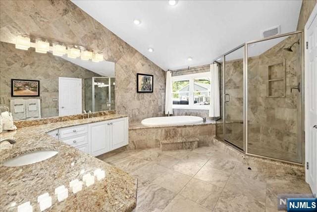 full bathroom featuring lofted ceiling, a garden tub, visible vents, vanity, and a stall shower