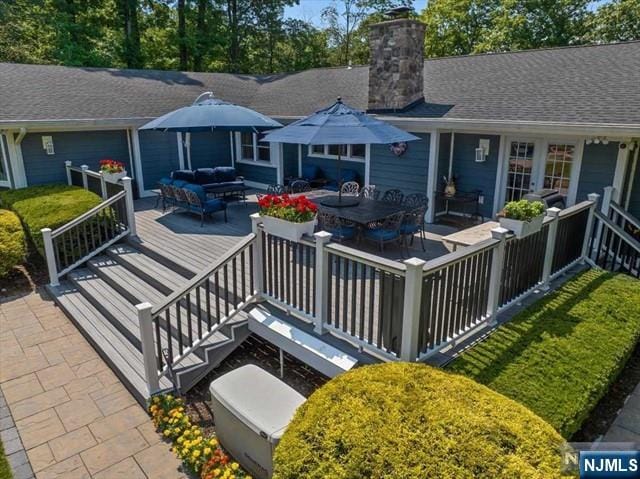 back of property featuring an outdoor hangout area, roof with shingles, a chimney, and a wooden deck