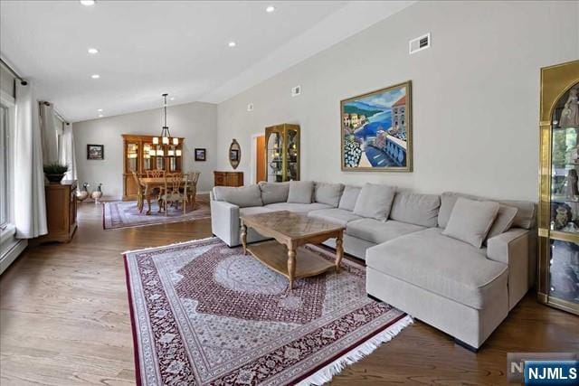 living room featuring lofted ceiling, visible vents, wood finished floors, and recessed lighting