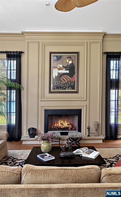 85 Buckhaven Hl, Upper Saddle River, NJ 07458 - living room with light wood finished floors, a large fireplace, ornamental molding, and ceiling fan