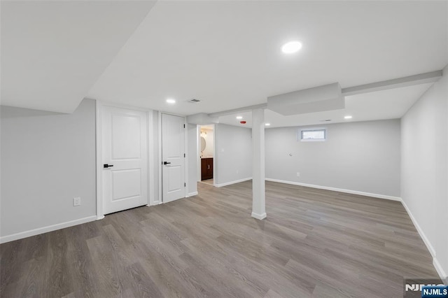 basement featuring recessed lighting, wood finished floors, and baseboards