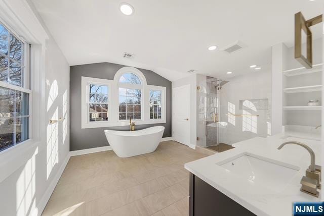 full bathroom with visible vents, baseboards, a soaking tub, vaulted ceiling, and a shower stall