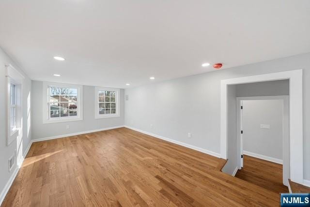 empty room featuring light wood-type flooring, recessed lighting, visible vents, and baseboards