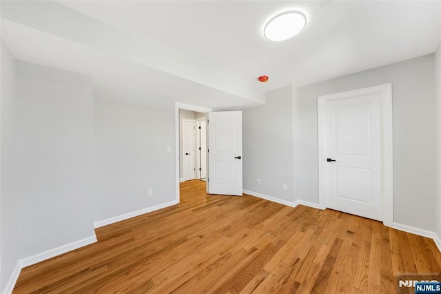 unfurnished bedroom featuring light wood finished floors and baseboards