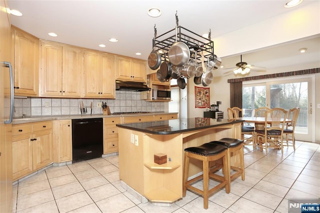 kitchen featuring light tile patterned floors, decorative backsplash, appliances with stainless steel finishes, under cabinet range hood, and light brown cabinets