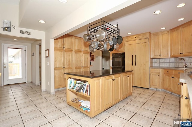 kitchen featuring light tile patterned floors, light brown cabinets, paneled refrigerator, and oven