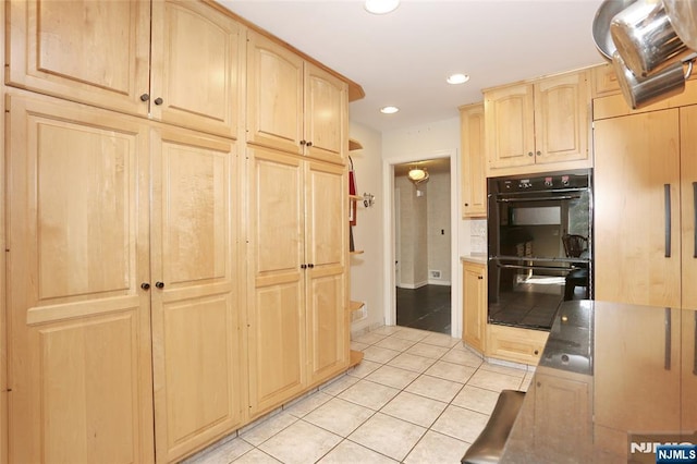 kitchen with light tile patterned floors, recessed lighting, light countertops, dobule oven black, and light brown cabinets