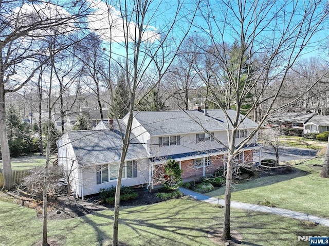 traditional-style house with a chimney and a front yard