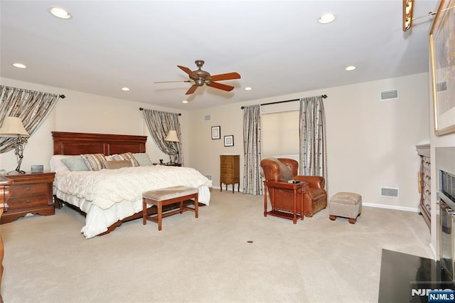 bedroom with carpet floors, a fireplace with flush hearth, visible vents, and recessed lighting