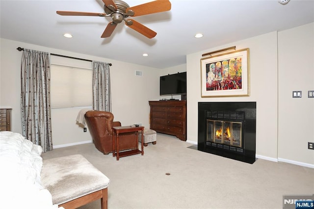 carpeted living area featuring baseboards, a fireplace with flush hearth, visible vents, and recessed lighting