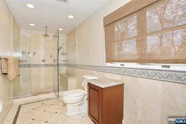 full bathroom featuring tile patterned flooring, toilet, recessed lighting, tile walls, and a stall shower