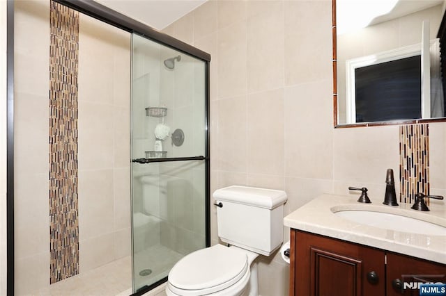 bathroom with decorative backsplash, toilet, vanity, a shower stall, and tile walls