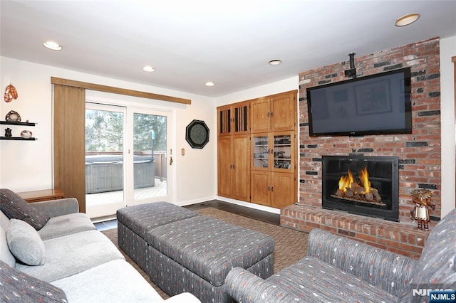 living area with baseboards, a brick fireplace, and recessed lighting