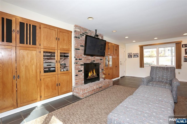 living room with recessed lighting, a brick fireplace, and baseboards