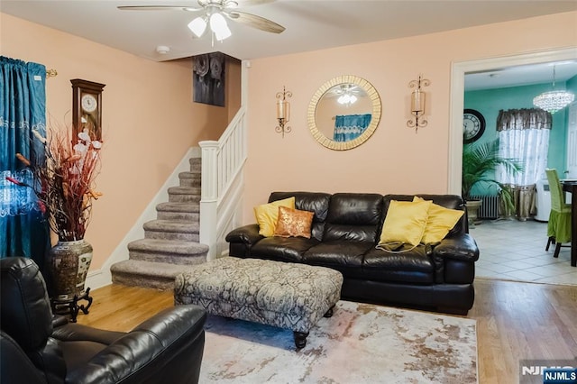 living area featuring ceiling fan, stairs, and wood finished floors