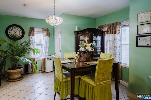 dining room with a chandelier, a baseboard radiator, and tile patterned flooring