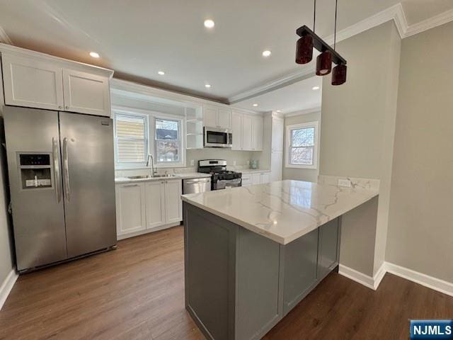 kitchen with crown molding, a sink, appliances with stainless steel finishes, and white cabinetry