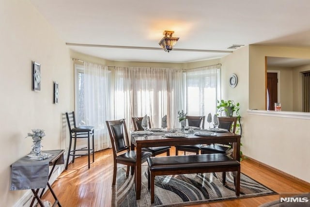 dining area with visible vents and wood finished floors