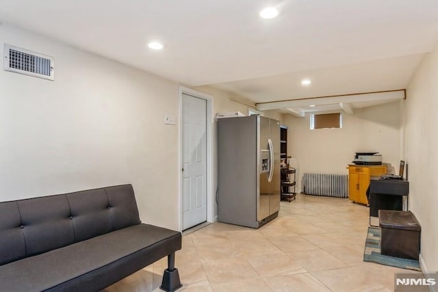 living area with radiator, light tile patterned flooring, visible vents, and recessed lighting