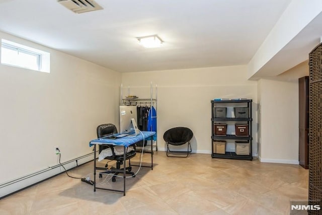 interior space featuring a baseboard heating unit, visible vents, and baseboards