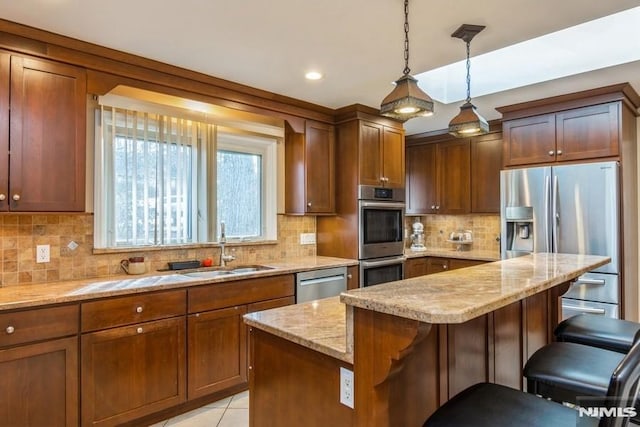 kitchen featuring a center island, a breakfast bar area, backsplash, appliances with stainless steel finishes, and a sink