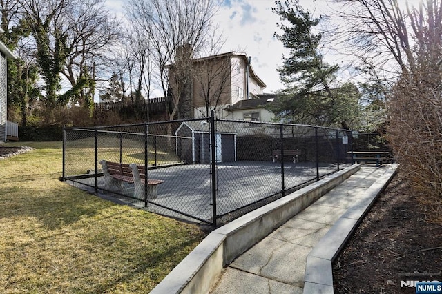 view of sport court with a yard and fence