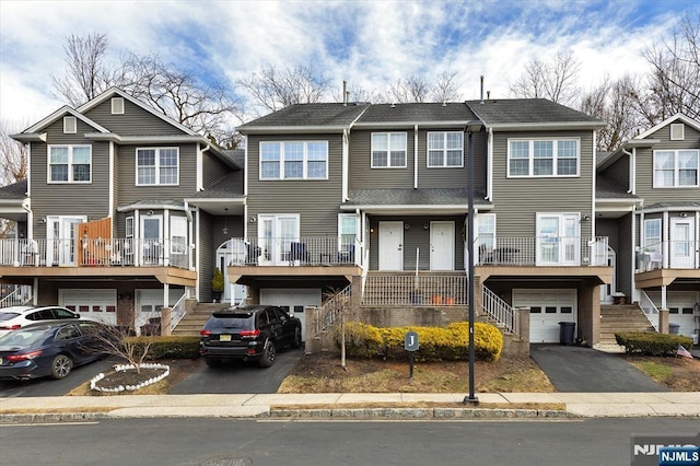 multi unit property featuring a garage, stairs, and aphalt driveway