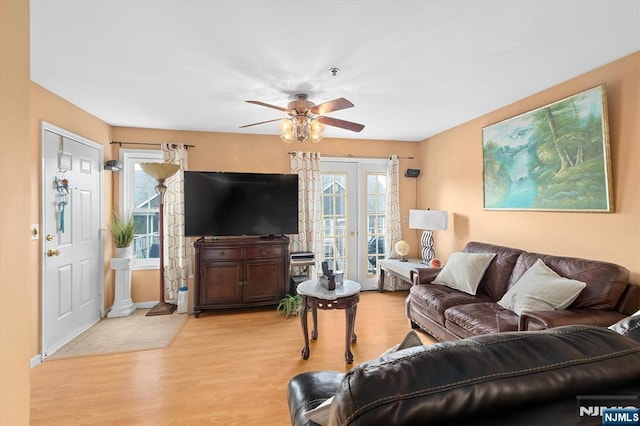 living room with ceiling fan, french doors, and light wood-type flooring