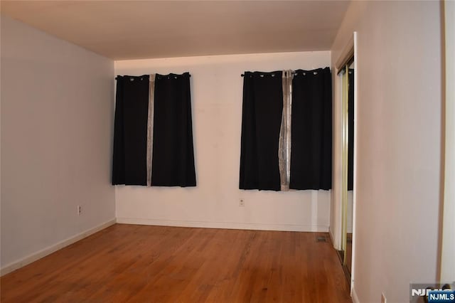 spare room with wood finished floors and baseboards