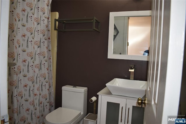 bathroom with toilet, vanity, and a shower with curtain