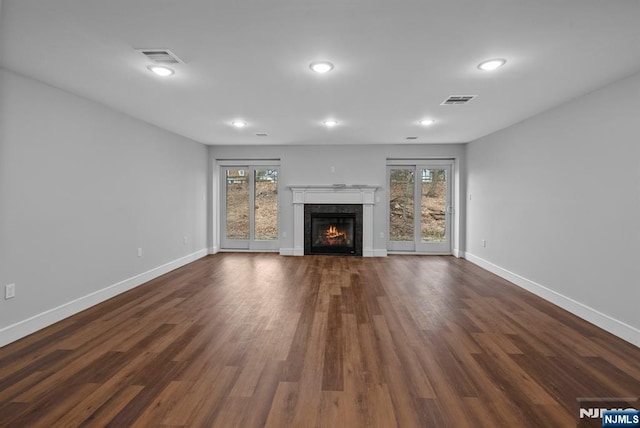 unfurnished living room featuring dark wood-style floors, visible vents, and baseboards