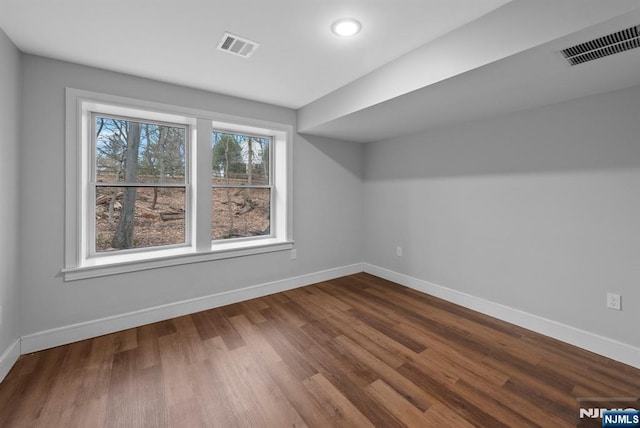 bonus room featuring dark wood finished floors, visible vents, and baseboards